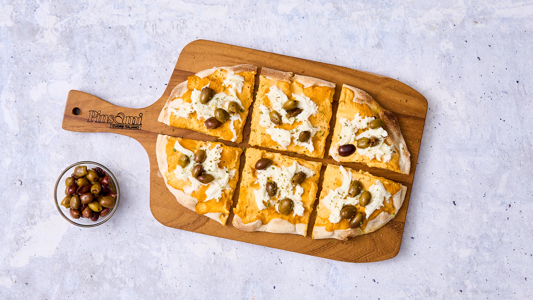 Pinsa con crema di peperoni, straccetti di mozzarella e olive